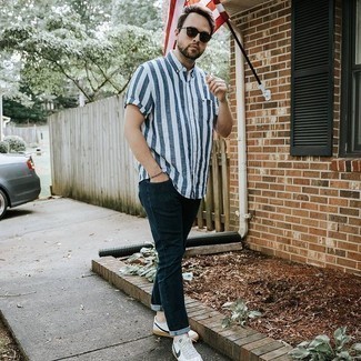 Men's White and Navy Vertical Striped Short Sleeve Shirt, Navy Jeans, White and Navy Leather Low Top Sneakers, Dark Brown Sunglasses