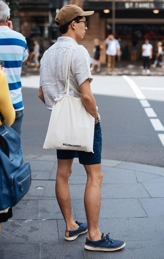 White Print Canvas Tote Bag Outfits For Men: This pairing of a light blue linen short sleeve shirt and a white print canvas tote bag is very easy to do and so comfortable to work from dawn till dusk as well! To add more class to your getup, finish with navy canvas low top sneakers.