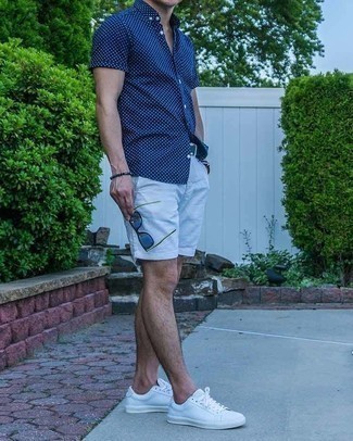 Olive Leather Belt Outfits For Men: This off-duty combo of a navy and white polka dot short sleeve shirt and an olive leather belt is simple, on-trend and very easy to replicate. Here's how to infuse an air of class into this outfit: white canvas low top sneakers.