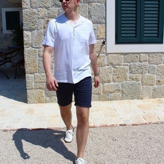 Navy Shorts Outfits For Men: This laid-back pairing of a white short sleeve shirt and navy shorts is very easy to throw together in no time flat, helping you look dapper and prepared for anything without spending a ton of time going through your wardrobe. This outfit is completed perfectly with white canvas low top sneakers.