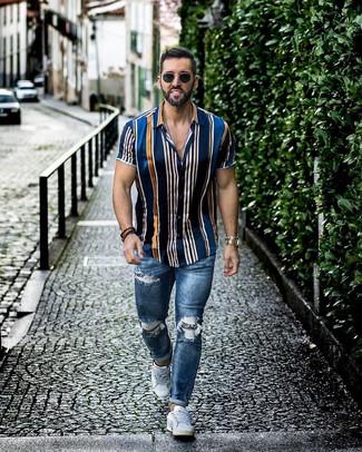 Navy and White Vertical Striped Short Sleeve Shirt with Skinny Jeans Outfits For Men: For an edgy look, Try pairing a navy and white vertical striped short sleeve shirt with skinny jeans. A good pair of white low top sneakers is an effortless way to punch up this ensemble.