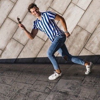 Blue Ripped Skinny Jeans Outfits For Men: A white and blue vertical striped short sleeve shirt and blue ripped skinny jeans are essential in any guy's properly edited casual wardrobe. White and black print canvas low top sneakers are guaranteed to inject a dose of class into this getup.