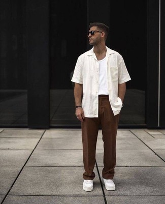 Sunglasses Outfits For Men: If you don't take fashion too seriously, go for laid-back and cool menswear style in a white short sleeve shirt and sunglasses. You can follow the classic route in the footwear department by wearing a pair of white leather low top sneakers.