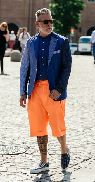 Nick Wooster wearing Grey Canvas Slip-on Sneakers, Orange Shorts, Navy Dress Shirt, Navy Vertical Striped Blazer