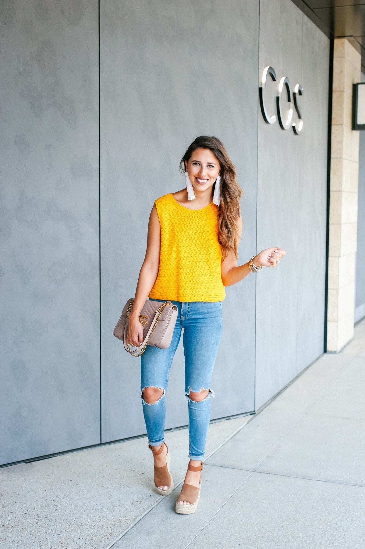 Women's Yellow Knit Sleeveless Top, Light Blue Ripped Skinny Jeans, Brown  Suede Wedge Sandals, Beige Quilted Leather Satchel Bag | Lookastic