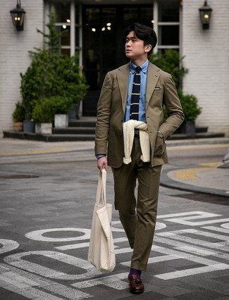 Beige Print Canvas Tote Bag Outfits For Men: Effortlessly blurring the line between dapper and off-duty, this pairing of an olive suit and a beige print canvas tote bag will easily become your go-to. For a more sophisticated touch, why not introduce a pair of dark brown leather tassel loafers to the equation?