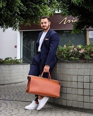 Dark Brown Leather Holdall Outfits For Men: This pairing of a navy suit and a dark brown leather holdall combines comfort and practicality and helps you keep it low profile yet trendy. Make white canvas low top sneakers your footwear choice and the whole ensemble will come together.