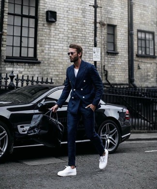 Black Leather Duffle Bag Outfits For Men: Who said you can't make a fashionable statement with a relaxed getup? That's easy in a navy suit and a black leather duffle bag. If not sure as to the footwear, complete your getup with white canvas low top sneakers.