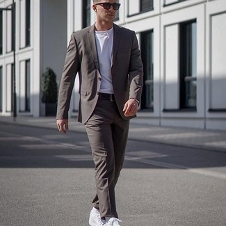 Dark Brown Suit with White Canvas Low Top Sneakers Outfits In Their 20s: Go for a simple but classy ensemble by wearing a dark brown suit and a white crew-neck t-shirt. For a stylish hi/low mix, complete this ensemble with a pair of white canvas low top sneakers. A great example for anyone who wonders how to dress as a young gentleman.