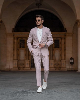 Pink Suit Outfits: Consider teaming a pink suit with a white crew-neck t-shirt to assemble a proper and polished menswear style. To add a more casual vibe to your outfit, introduce a pair of white canvas low top sneakers to the equation.