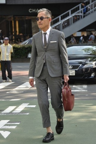 Red Leather Briefcase Outfits: This laid-back pairing of a grey suit and a red leather briefcase is a real lifesaver when you need to look casual and cool but have zero time. Why not take a more elegant approach with footwear and introduce a pair of black leather brogues to the mix?