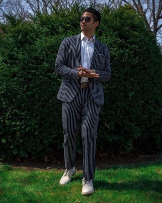 Brown Leather Belt Outfits For Men: This combination of a navy vertical striped suit and a brown leather belt is extra versatile and creates instant appeal. And if you need to immediately ramp up your getup with footwear, add white canvas brogues to the mix.