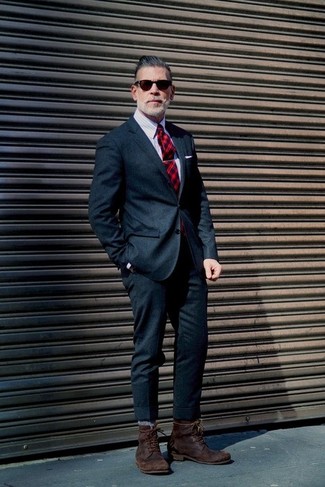A navy wool suit looks especially elegant when worn with a grey vertical striped dress shirt in a modern man's getup. For times when this outfit appears too classic, dial it down by rounding off with a pair of dark brown leather casual boots.