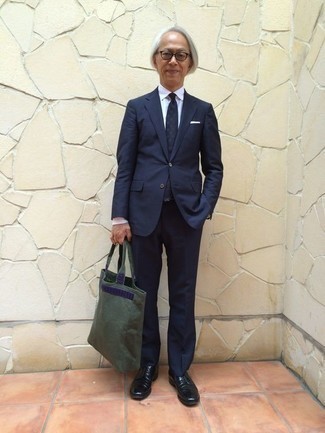 Olive Canvas Tote Bag Outfits For Men: A navy suit and an olive canvas tote bag will convey this relaxed and dapper vibe. Let your styling expertise truly shine by completing this look with black leather derby shoes.
