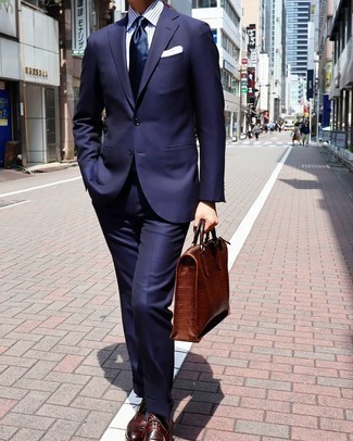 Briefcase Outfits: A navy suit and a briefcase are an easy way to introduce some cool into your daily fashion mix. Make a bit more effort with footwear and introduce a pair of burgundy leather derby shoes to the mix.