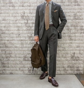 Brown Canvas Backpack Outfits For Men: A charcoal suit and a brown canvas backpack are a pairing that every sartorially savvy guy should have in his casual arsenal. Amp up the formality of your ensemble a bit by finishing off with dark brown leather double monks.