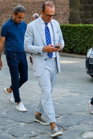 Grey Low Top Sneakers Outfits For Men: Opt for a light blue vertical striped suit and a white dress shirt - this look is bound to make an entrance. Introduce a pair of grey low top sneakers to your look to immediately bump up the appeal of your ensemble.