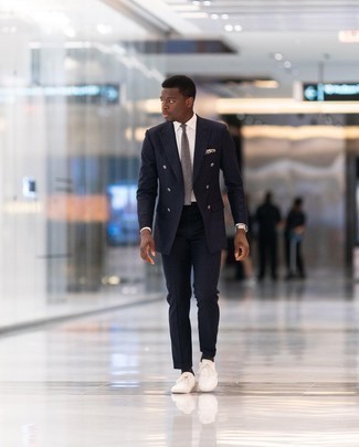 Charcoal Tie Outfits For Men: Try teaming a navy vertical striped suit with a charcoal tie for elegant style with a twist. And it's amazing how a pair of white canvas low top sneakers can update an ensemble.