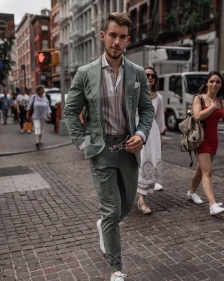 Green Suit Outfits: A green suit and a white and brown vertical striped dress shirt are strong sartorial weapons in any modern gent's arsenal. Not sure how to finish? Complement this look with white canvas low top sneakers to spice things up.