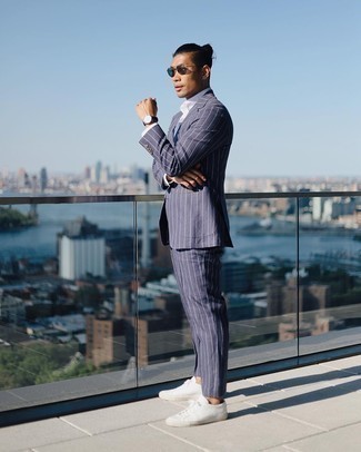 Navy Vertical Striped Suit with White Low Top Sneakers Smart Casual Outfits: To look crisp and smart, wear a navy vertical striped suit with a white dress shirt. Dial up this whole look by finishing off with a pair of white low top sneakers.