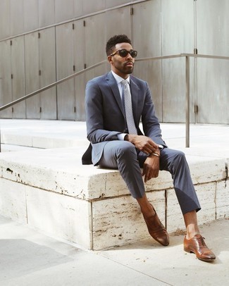Navy Suit Outfits: To look smooth and smart, consider wearing a navy suit and a white dress shirt. When not sure as to what to wear when it comes to footwear, stick to a pair of brown leather oxford shoes.