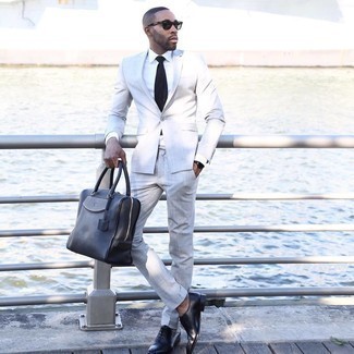 Black and White Leather Tote Bag Outfits For Men: This casual pairing of a grey suit and a black and white leather tote bag is perfect when you need to feel confident in your getup. Infuse this look with a touch of class by slipping into black leather oxford shoes.