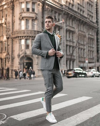 Dark Green Hoodie Outfits For Men: For an effortlessly classic ensemble, consider pairing a dark green hoodie with a grey vertical striped suit — these pieces play really nice together. If you want to instantly dress down your getup with footwear, complement this outfit with white and green leather low top sneakers.