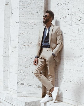Beige Suit Smart Casual Outfits: A beige suit and a navy chambray long sleeve shirt are absolute wardrobe heroes if you're piecing together a stylish wardrobe that holds to the highest sartorial standards. Have some fun with things and complete this ensemble with white canvas low top sneakers.