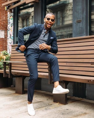 Navy Suit Outfits: Pairing a navy suit and a light blue polka dot polo is a guaranteed way to infuse style into your wardrobe. Spice up your outfit with a more casual kind of shoes, like this pair of white canvas low top sneakers.