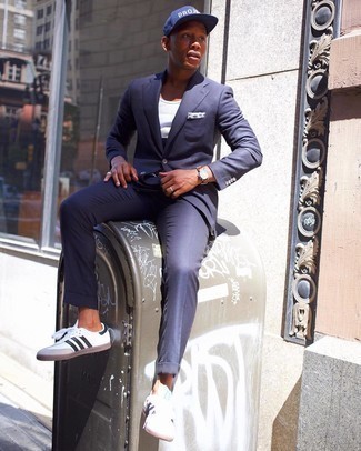 Navy Suit Outfits: You'll be surprised at how very easy it is for any gent to get dressed like this. Just a navy suit and a grey horizontal striped tank. White and black leather low top sneakers will create a stylish contrast against the rest of the ensemble.