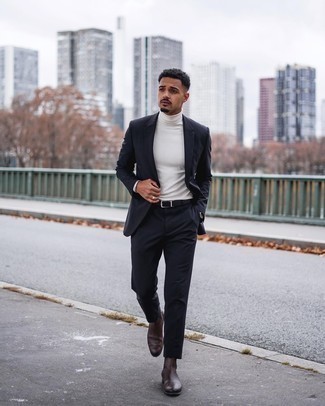 Navy Suit Outfits: Wear a navy suit and a white turtleneck and you're bound to make a bold statement. A pair of dark brown leather chelsea boots looks great here.
