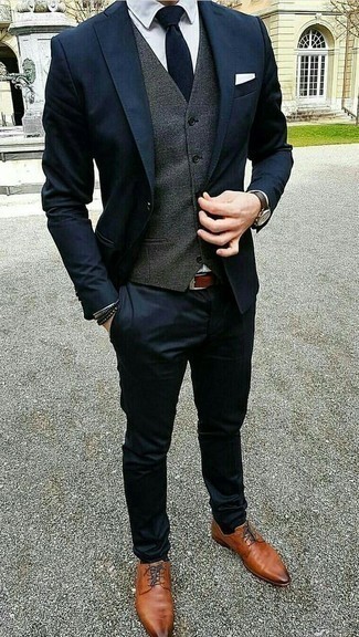 Grey Waistcoat Outfits: We love the way this combo of a grey waistcoat and a navy suit instantly makes you look classy and smart. Here's how to dial down this ensemble: tobacco leather derby shoes.