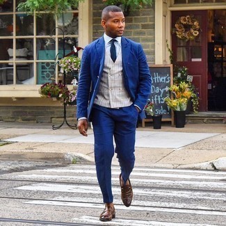 Navy Suit Outfits: Pairing a navy suit and a grey plaid waistcoat is a guaranteed way to infuse rugged elegance into your styling routine. To give your overall outfit a more casual finish, why not add a pair of brown leather loafers to the mix?