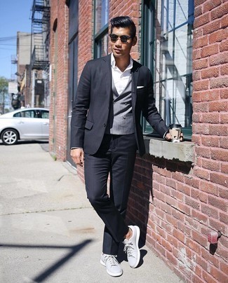 Black Vertical Striped Suit Outfits: Combining a black vertical striped suit and a grey vertical striped waistcoat is a guaranteed way to infuse your styling collection with some masculine sophistication. Change up your outfit with more relaxed footwear, such as this pair of grey leather low top sneakers.