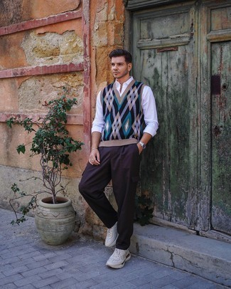 Black Argyle Sweater Vest Outfits For Men: This pairing of a black argyle sweater vest and dark brown cargo pants will add powerful essence to your look. To infuse a carefree vibe into your ensemble, complement your look with a pair of beige athletic shoes.