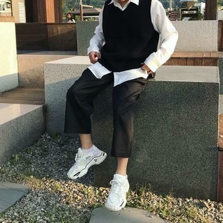 White Athletic Shoes Outfits For Men: Nail the effortlessly classic outfit in a black sweater vest and black chinos. Add a more casual twist to an otherwise sober look with white athletic shoes.