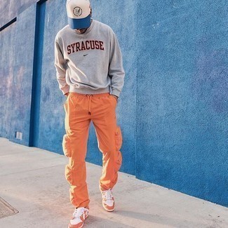 Grey Print Sweatshirt Outfits For Men: This relaxed pairing of a grey print sweatshirt and orange cargo pants is a goofproof option when you need to look nice in a flash. Complete your outfit with orange leather low top sneakers et voila, your ensemble is complete.