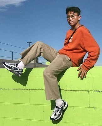 Orange Sweatshirt Outfits For Men: If the situation permits an off-duty look, go for an orange sweatshirt and khaki chinos. When this ensemble is too much, play it down by slipping into white and black athletic shoes.