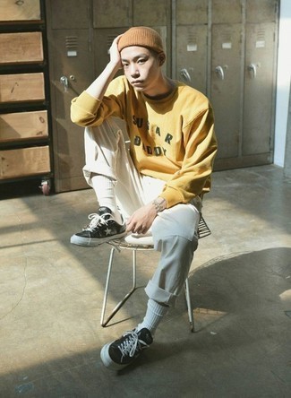 Yellow Sweatshirt Outfits For Men: Extremely stylish and practical, this casual pairing of a yellow sweatshirt and white chinos provides countless styling possibilities. Let your styling sensibilities really shine by completing your look with a pair of black and white star print leather low top sneakers.