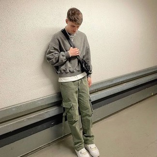 Black Canvas Fanny Pack Outfits For Men: A grey sweatshirt and a black canvas fanny pack teamed together are the ideal look for those dressers who love cool and relaxed styles. You know how to give a touch of polish to this getup: white leather low top sneakers.