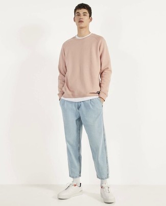 Pink Sweatshirt Outfits For Men: Wear a pink sweatshirt with light blue jeans for an effortless kind of refinement. All you need now is a cool pair of white leather low top sneakers to finish this outfit.