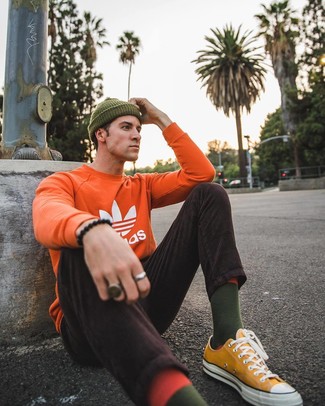 Dark Green Beanie Outfits For Men: Dress down for the day in this practical combo of an orange print sweatshirt and a dark green beanie. For a more elegant aesthetic, add mustard canvas low top sneakers to the mix.