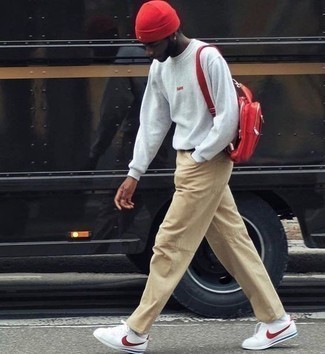 Red Leather Backpack Outfits For Men: This off-duty combination of a grey sweatshirt and a red leather backpack is a fail-safe option when you need to look stylish in a flash. Introduce white and red canvas low top sneakers to the mix to immediately amp up the wow factor of any ensemble.