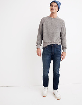 White and Blue Canvas Low Top Sneakers Outfits For Men: If you're after an off-duty and at the same time dapper look, make a grey sweatshirt and navy jeans your outfit choice. Add a pair of white and blue canvas low top sneakers to this getup and the whole ensemble will come together.