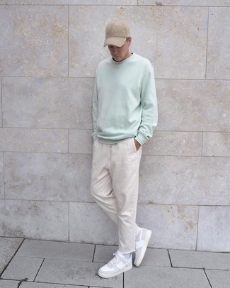 Tan Baseball Cap Outfits For Men: This combination of a mint sweatshirt and a tan baseball cap is super easy to throw together and so comfortable to rock a version of as well! White leather low top sneakers are a surefire way to give an extra dose of elegance to this look.
