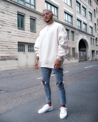 Blue Ripped Skinny Jeans Outfits For Men: A white sweatshirt and blue ripped skinny jeans are a casual street style combination that every modern gent should have in his closet. Get a little creative on the shoe front and lift up your outfit by slipping into a pair of white canvas low top sneakers.