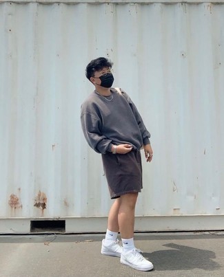 Dark Brown Sports Shorts Outfits For Men: For a foolproof laid-back option, you can't go wrong with this combination of a charcoal sweatshirt and dark brown sports shorts. Finishing off with white canvas low top sneakers is a surefire way to bring some extra elegance to your ensemble.