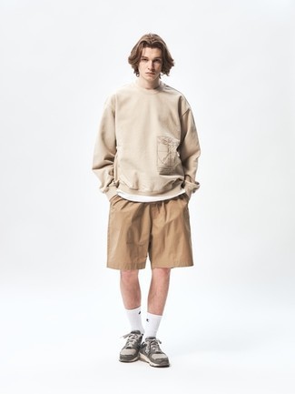 Men's Outfits 2022: A beige sweatshirt and tan shorts are a good outfit formula to keep in your closet. Why not complete your getup with grey athletic shoes for a mellow touch?