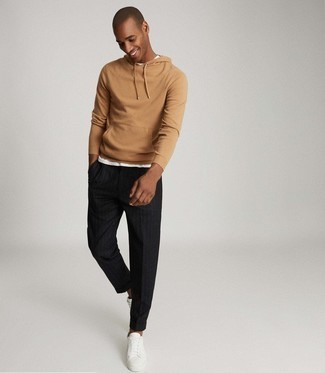 Black Vertical Striped Chinos Outfits: A tan knit hoodie and black vertical striped chinos worn together are a match made in heaven. If you're hesitant about how to finish, a pair of white leather low top sneakers is a good pick.