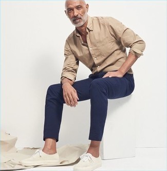 Navy Chinos Casual Outfits After 50: Infuse new life into your day-to-day casual fashion mix with a tan long sleeve shirt and navy chinos. To introduce a playful feel to your getup, complement this ensemble with white canvas low top sneakers. Like this idea for your styling collection as a mature gentleman?